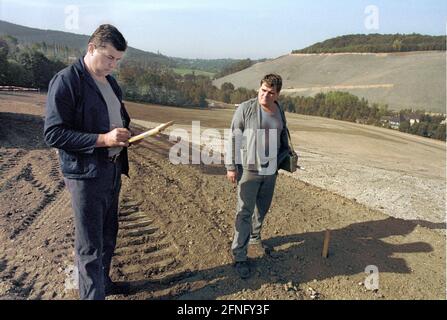 Sachsen / DDR / Energie / 1992 Uranhalden in Schlema bei Aue, Messung der Radioaktivität. Die Sanierung der größeren Umweltschäden hat begonnen. Die Müllkippe ist abgeflacht und es werden Terrassen angelegt, Büsche gepflanzt. Der Zugang für die Bevölkerung wird für eine sehr lange Zeit nicht möglich sein. Die Sanierung wird von DER WISMUT AG durchgeführt. Ein Bagger verteilt eine Mischung aus Oberboden und Asche. // Erzgebirge / Umwelt / Atom / Uran / Bergbau die deutsch-sowjetische Aktiengesellschaft wurde nach der Gründung der DDR gegründet, um der Sowjetunion weiterhin Zugang zum Uran in den zu ermöglichen Stockfoto