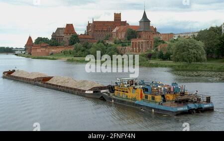 PL / Polen / Schlösser 7/1993 Marienburg am Nogat, Zentralburg der Deutschen Ritter, Stützpunkt für die Eroberung des Ostens für das Deutsche Reich. Vor einem Lastkahn auf der Nogat // Geschichte / Verkehr / Wasser / Ostpreußen ab 1309 war die Burg Sitz der Deutschen Ritter, die von Venedig hierher zogen. Von dieser Basis aus wurden die Pruzzen im Norden unterjocht und eine Reihe weiterer Kriege geführt. Der Niedergang des Ordens begann 1410 mit einer Niederlage gegen Polen und Litauen. Schließlich mussten die kirchlichen Ritter das Schloss an Soeldner verpfänden, die es an die verkauften Stockfoto