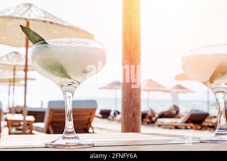 Ein Glas gefrorener Margarita-Cocktail am Strand. Stockfoto