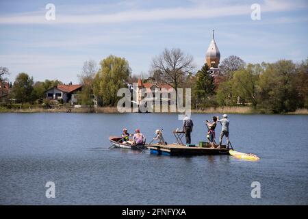 Gruppe von Leuten, die eine Tauchplattform in die Mitte des Wesslingsees schleppen, Oberbayern, Deutschland, Europa. Stockfoto