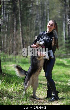 Nettes Mädchen umarmt die Husky. Husky sind die besten Freunde. Stockfoto