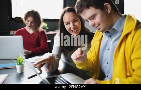 Down-Syndrom-Mann, der die Bildungsklasse im Gemeindezentrum besucht, einschließlich der Behinderten. Stockfoto