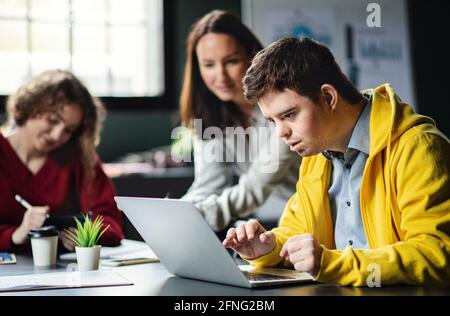 Down-Syndrom-Mann, der die Bildungsklasse im Gemeindezentrum besucht, einschließlich der Behinderten. Stockfoto