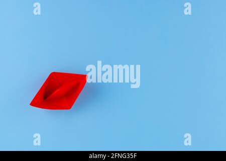 Rotes Papierboot auf blauem Hintergrund. Stockfoto
