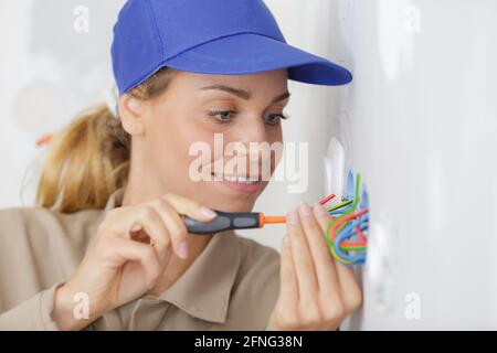 Nahansicht einer Elektrikerin, die an der Verkabelung arbeitet Stockfoto