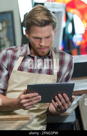 Mann mit digitalem Tablet in der Werkstatt Stockfoto