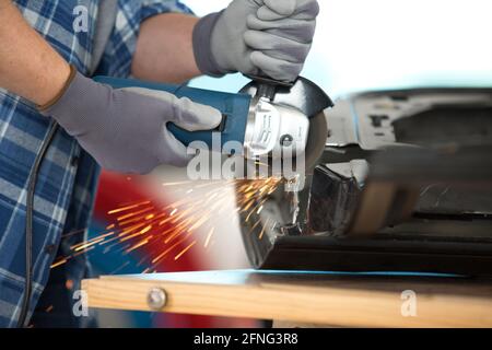 Nahaufnahme des professionellen Schmieds, der Metall mit einer Hand-Rundum-Schneide sägt Stockfoto