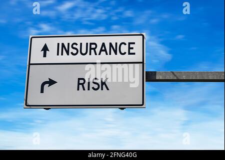Straßenschild mit den Worten Versicherung und Risiko. Weiße zwei Straßenschilder mit Pfeil auf Metallmast auf blauem Himmel Hintergrund. Stockfoto