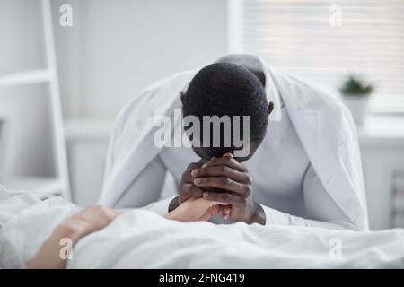 Afrikanischer junger Mann, der sich um die Gesundheit seines Freundes sorgt Auf der Krankenstation Stockfoto