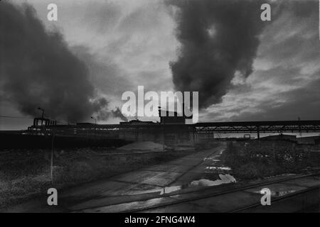 Sachsen-Anhalt / Industrie / DDR / 12/1989 Sonnenuntergang hinter dem Kraftwerk in Bitterfeld, einem Teil des Braunkohleskohlekombinat. Das Kraftwerk lieferte unter anderem auch den Chemiekombinat, das Aluminiumwerk. Es wurde abgerissen. Die anderen Anlagen wurden aufgeteilt und privatisiert // Energie / Umwelt / Bundesländer [automatisierte Übersetzung] Stockfoto