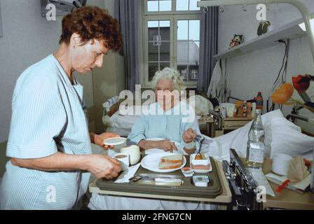 Berlin / Gesundheit / Krankenhaus / 1997 Krankenhaus Prenzlauer Berg, interne Abteilung. Krankenschwester bringt Frühstück, alte Patientin // alte Menschen / Senioren / Frauen arbeiten / [automatisierte Übersetzung] Stockfoto