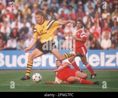 FC Bayern München - Borussia Dortmund 3:0/12.05.1990. Thomas Helmer (BVB) springt über Hans Dorfner. Hinten: Olaf Thon (beide FCB). [Automatisierte Übersetzung] Stockfoto