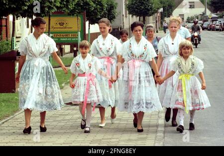 Brandenburg / Sachsen / Minderheiten / 1996 Dreitappelreiten der Sorben in Raddusch. Ein alter Brauch der Sorben. Nach der Ernte finden auf den Feldern Reitwettbewerbe statt. Die Frauen des Dorfes gehen auf das Schlachtfeld // Wenden / Lausitz / Kostüm / Jugend / die Osteroberung in Ostdeutschland wurde bereits von Karl dem Großen begonnen, erlitt aber viele Rückschläge. 1168 wurde das große slawische Heiligtum auf Rügen von den Dänen zerstört und Albrecht der Bär eroberte die slawische Festung Brennabor, Brandenburg. Die Slawen wurden nach Osten zurückgedrängt. Ihre Nachfahren, den Sorben und Sorben, leben heute Stockfoto