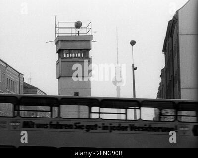 DDR, Berlin, 04.02.1990, Mauer an der Bernauer Straße, Wachturm und Bus, Fernsehturm, Strelitzer Straße, Stockfoto