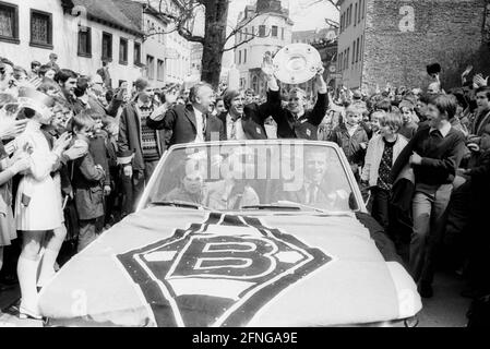 VFL Borussia Mönchengladbach Deutscher Fußballmeister 1969/70 bei der Fahrt durch die Stadt vor dem Auto von den linken Trainern Hennes Weisweiler, Günter Netzer und Berti Vogts mit Meisterschaftspokal.die Autokolonne wird von vielen Fans begleitet Stockfoto