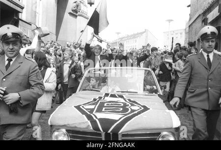 VFL Borussia Mönchengladbach Deutscher Fußballmeister 1969/70 während der Fahrt durch die Stadt vor dem Auto von dem linken Trainer Hennes Weisweiler mit Meisterschaftspokal, Günter Netzer und Berti Vogts, wird die Autokolonne von 2 Polizisten und vielen Fans begleitet. [Automatisierte Übersetzung] Stockfoto