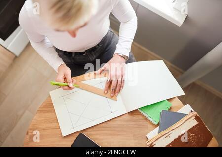 Von oben der Ernte nicht erkennbare weibliche Astrologen Zeichnung auf Papier Mit Dreieck und Stift am Tisch Stockfoto