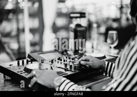 Schwarzer DJ spielt Musik an der Cocktailbar im Freien - Unterhaltung Und Party-Konzept - Fokus auf der rechten Hand Stockfoto