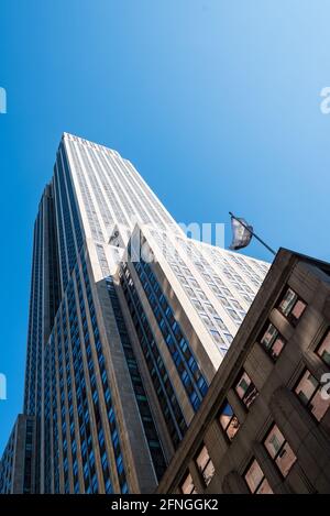 New York City, USA - 20. Juni 2018: Low-Angle-Ansicht des Empire State Building gegen blauen Himmel. Vertikal Stockfoto