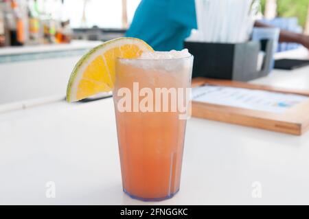 Nahaufnahme eines orangefarbenen Getränks mit Eis dekoriert mit Eine Limettenscheibe Stockfoto