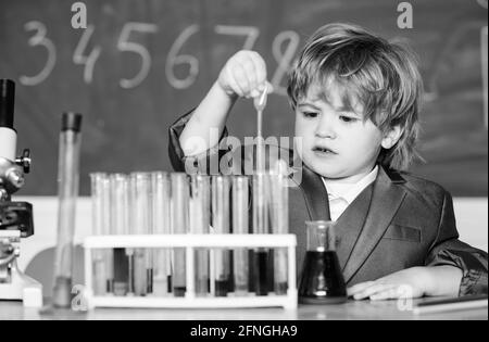 Lernen Sie für die Zukunft. Biologiewissenschaft. Kleiner Junge mit Mikroskop in der Schulstunde. Teströhrchen mit Flüssigkeit für die Forschung. Ergebnis. Medizinisches Konzept Stockfoto