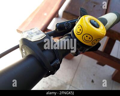 Limassol, Zypern - 10. Mai 2021: Gelbe Fahrradglocke am Lenker mit Smiley Face Emoji Stockfoto