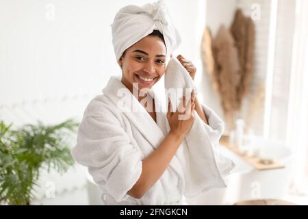 Schwarze Frau, Die Gesicht Trocknend, Tut Gesichtshaut Routine Im Badezimmer Stockfoto