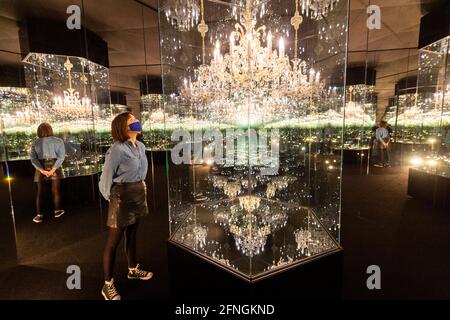 London, Großbritannien. 17 Mai 2021. Ein Tate-Mitarbeiter sieht „Chandelier of Gram“, 2016, von Yayoi Kusama. Vorschau auf Yayoi Kusama: Vom 18. Mai bis 12. Juni 2022 werden in Zusammenarbeit mit der Bank of America und mit zusätzlicher Unterstützung von UNIQLO die „InfinityMirror Rooms“ in der Tate Modern gezeigt. Kredit: Stephen Chung / Alamy Live Nachrichten Stockfoto