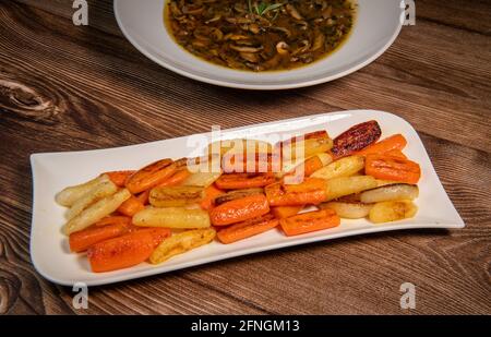 Chicken Hunter Rezept mit glasierten Wurzelgemüse, Karotte, Rübe mit seiner Pilzsauce in Weißwein entglasiert und mit der Hühnerbrühe nass Stockfoto