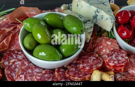 Wurstplatte mit italienischem Fleisch, Oliven, Paprika, Cracker, Wurst, Und Schinken-Prosciutto. Nahaufnahme, selektiver Fokus Stockfoto