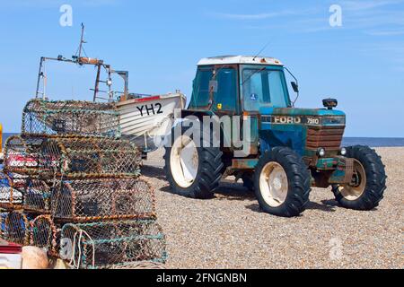 Hummertöpfe am Kiesstrand mit ford-Traktor und Fischerboot Stockfoto