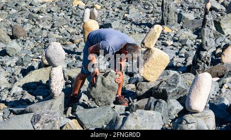 Kieselsteinskulpturen am Strand von St. Ives, Cornwall. Kiesel Bildhauer bei der Arbeit. Rock Balancing. Konzentration. Stockfoto