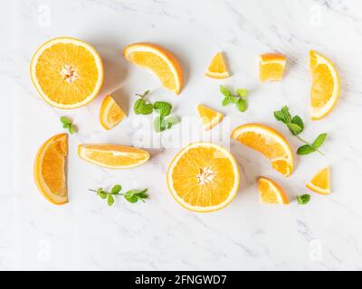 Verschiedene orangefarbene Fruchtscheiben auf weißem Marmorhintergrund, Draufsicht, Flachlage, Sommer und gesundes Konzept Stockfoto