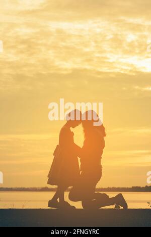 Silhouette Frau hält Luftballons stehen und sehen den See auf den Sonnenuntergang Stockfoto