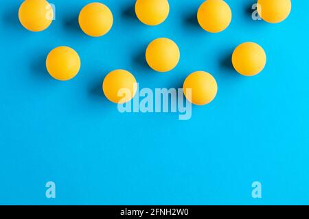 Orange Tischtennisbälle oder Tischtennisbälle auf blauem Hintergrund mit Kopierplatz. Stockfoto