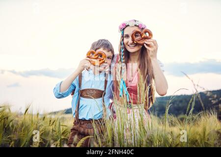 Mutter und Sohn in Bayern schauen durch Brezeln Stockfoto