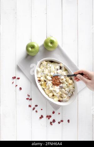 Zimt in der Füllung für den Apfelstrudel zusammen mit Äpfeln, Rosinen, Maismehl und geriebener Zitronenschale würzen. Stockfoto