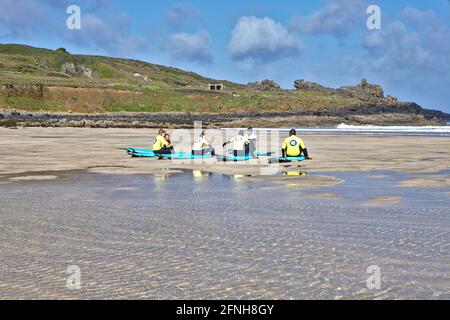 Morgendliche Surfer, die ihre Lektion am Porthmeor Beach besprechen Cornwall Stockfoto