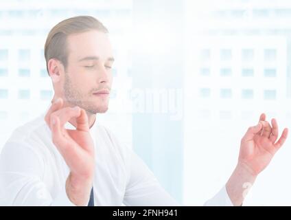 Komposition eines Geschäftsmannes mit geschlossenen Augen, meditiert mit blauen Flecken Von Licht im Hintergrund Stockfoto