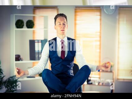 Komposition eines Geschäftsmannes mit geschlossenen Augen, meditierend über dem Büro schwebend Hintergrund Stockfoto