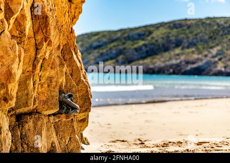 Professionelle Kletterschuhe auf dem Felsen am Strand mit Speicherplatz kopieren Stockfoto