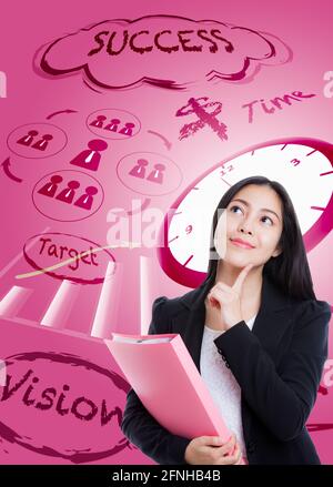 Schöne Frau, die mit dem Finger ins Gesicht schaut und pinken Dokumentenordner auf pinkem Hintergrund hält. Konzept des Entscheidungsprozesses. Asiatische Weibchen hat Stockfoto