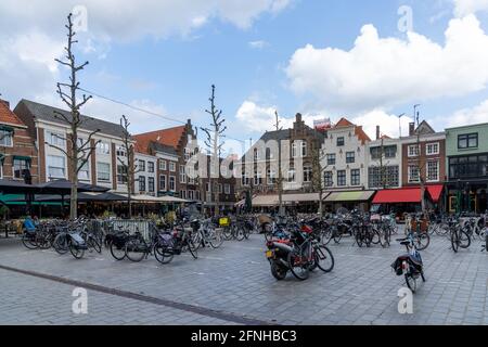 Goes, Niederlande - 12. Mai 2021: Stadtplatz in der niederländischen Stadt Goes mit vielen Gebäuden und geparkten Fahrrädern Stockfoto