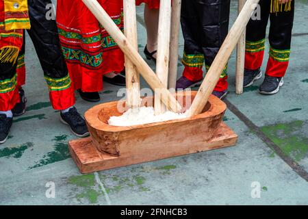 Eine Gruppe von Menschen, die mit Holzstäben klebrigem Reis hammerten Für die Herstellung von Reiskuchen mit Merkmalen der Guangxi Zhuang Nationalität Stockfoto