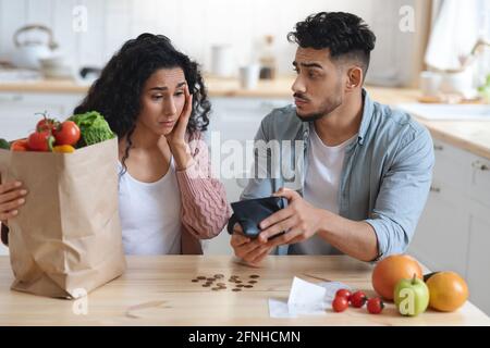 Coronacriris. Deprimierter Arabischer Partner In Der Küche, Der Das Verbleibende Geld Nach Dem Lebensmittelkauf Zählt Stockfoto