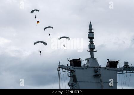 17. Mai 2021, Niedersachsen, Wilhelmshaven: Fallschirmjäger der Bundeswehr fliegen bei ihrer Inbetriebnahme über die Fregatte Sachsen-Anhalt. Die Sachsen-Anhalt ist die dritte von insgesamt vier Fregatten der neuen F125-Klasse. Foto: Sina Schuldt/dpa Stockfoto