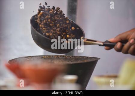 Addis Abeba. Mai 2021. Am 14. Mai 2021 röstet ein Kaffeekocher Kaffeebohnen in einem Straßencafe in Addis Abeba, Äthiopien. Äthiopien wird oft als die Geburtsstätte des Kaffees bezeichnet, während die traditionelle Kaffezeremonie, die ausschließlich die natürliche Verarbeitungsmethode beinhaltet, ein integraler Bestandteil der äthiopischen Gesellschaft ist. DAZU kommt: "Feature: Wachsende Zahl junger äthiopischer Frauen nutzen traditionellen Kaffee als lebensfähige Einkommensquelle" Kredit: Michael Tewelde/Xinhua/Alamy Live News Stockfoto