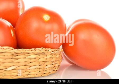 Mehrere leuchtend rote saftige Tomaten mit Strohplatte, Nahaufnahme, auf weißem Hintergrund. Stockfoto