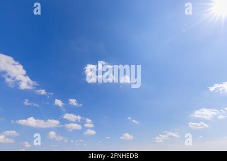 Blauer Himmel mit Wolken mit Perspektive und Sonne mit Strahlen In der oberen rechten Ecke (Licht rechts) Stockfoto