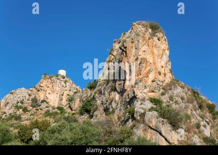 Scopello, Trapani, Sizilien, Italien. Blick aus dem Tal auf den Torre Bennistra, einen restaurierten mittelalterlichen Wachturm, der heute ein Clifftop mirador ist. Stockfoto